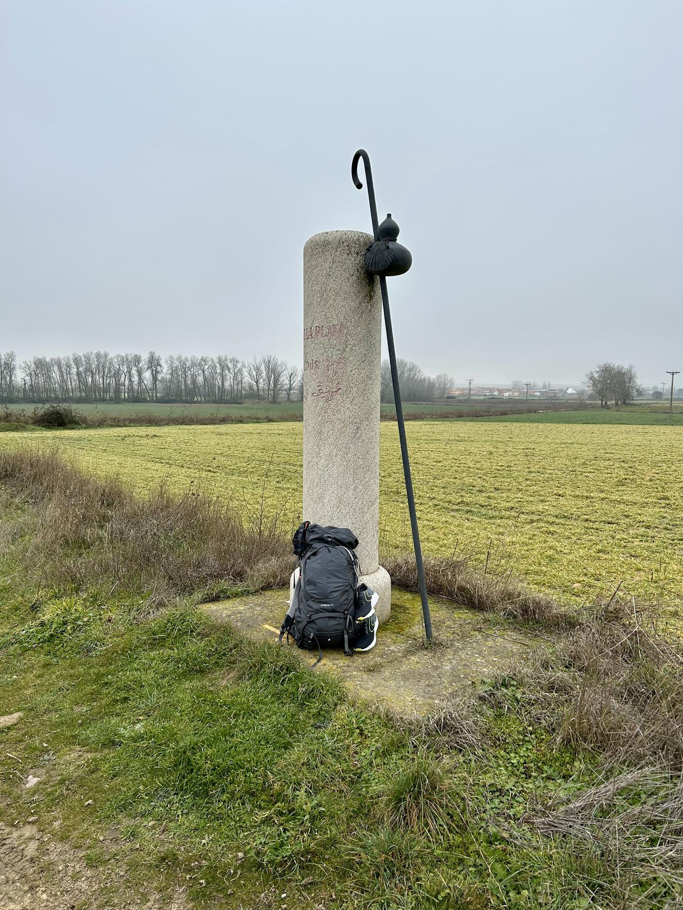 Pelgrimsstaf, kalebas en rugzak bij paal op de Vía de la Plata